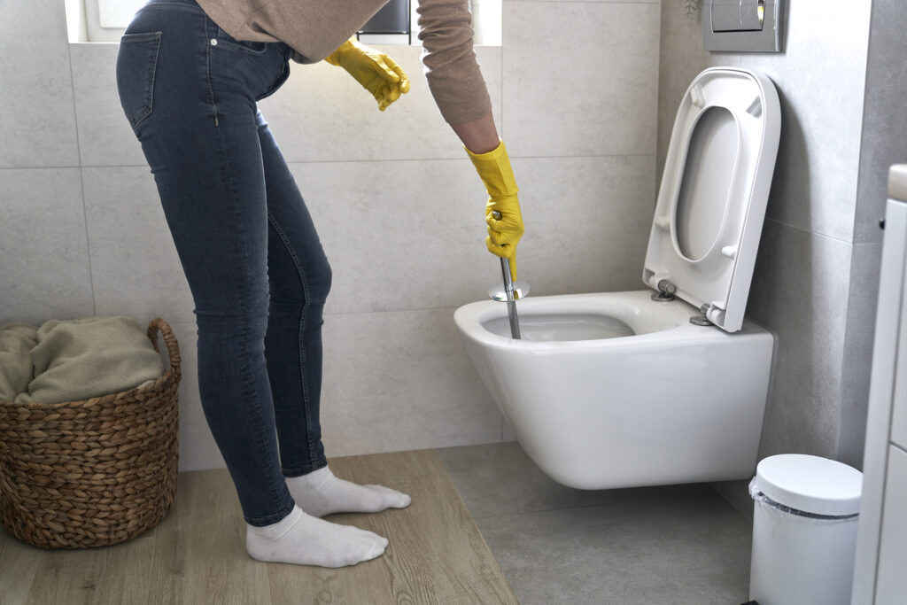 Unrecognizable woman cleaning bathroom toilet
