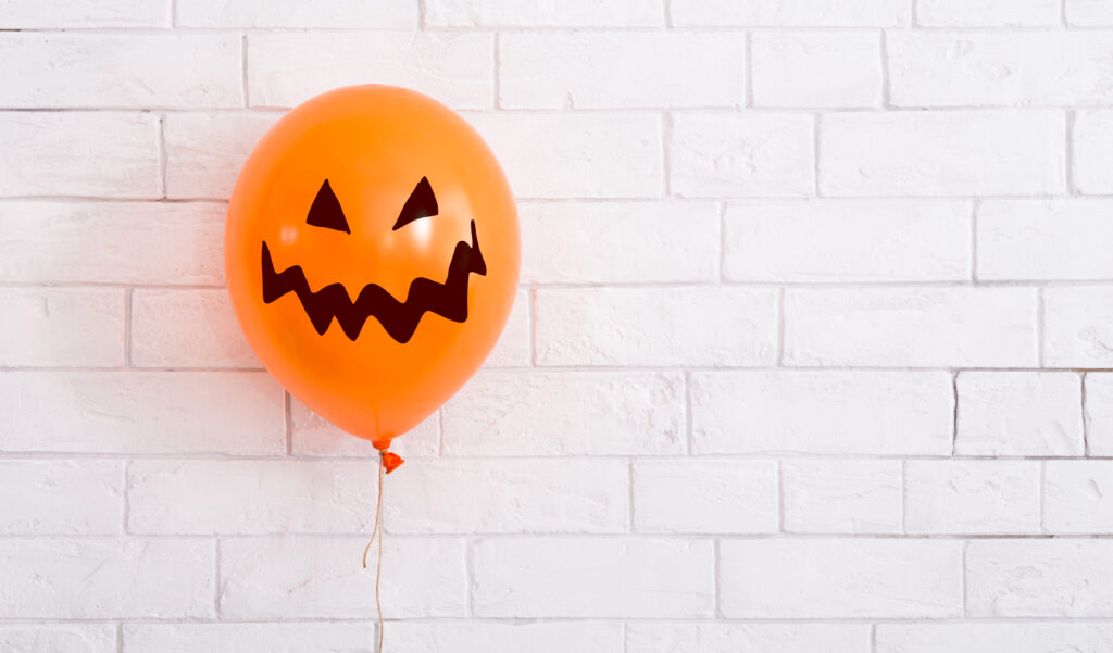 Conceptual Halloween balloon for party with scary smile on white background, panorama, copy space